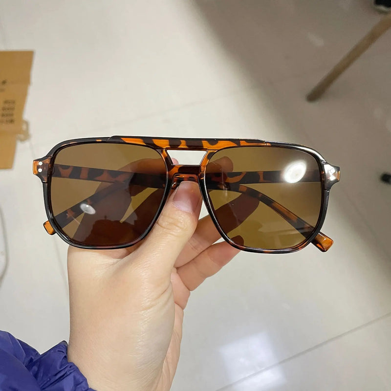 Óculos de Sol Vintage Unissexo – Design Quadrado, Estilo Premium
Destaque-se com estes óculos de sol vintage de grande dimensão, ideais para homens e mulheres que valorizam estilo e proteção. Com armação quadrada e a