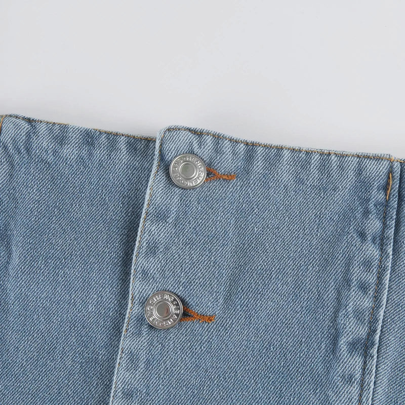 Top denim feminino estilo streetwear, com design elegante e sensual. Modelo cropped com decote quadrado e alças finas tipo suspensório, sem mangas, justo ao corpo e com fecho frontal em botões. Confeccionado em ganga de co