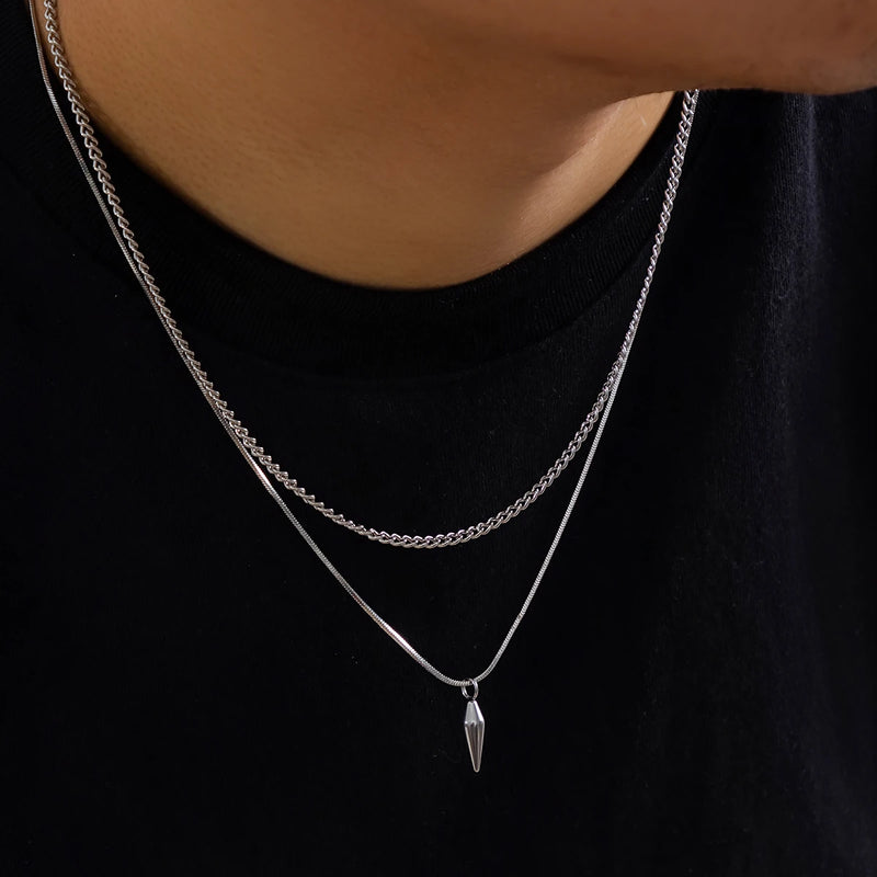 Conjunto de 2 Colares KunJoe – Estilo Punk Masculino
Destaque-se com atitude e estilo urbano.
Este conjunto inclui dois colares distintos em aço inoxidável:

1 Cuban Choker com elos largos

1 Colar com pingente de rebite