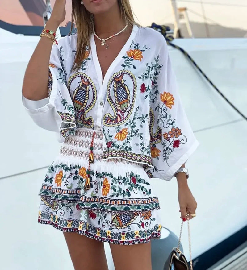 Descubra este conjunto exclusivo com design inspirado nas tendências europeias e americanas. Composto por uma camisola de decote em V solta e confortável, combinada com uma saia de corte reto e bordado artesanal, é perfeit